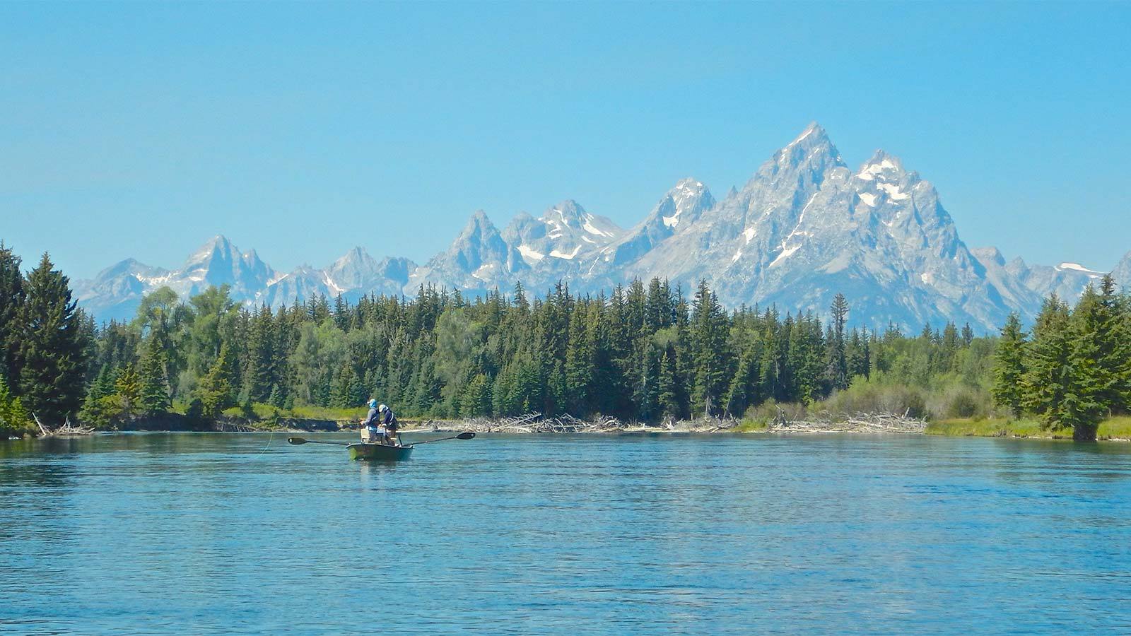 Jackson Hole Full Day Fly Fishing Trips wide shot of anglers in boat floating down the snake river.