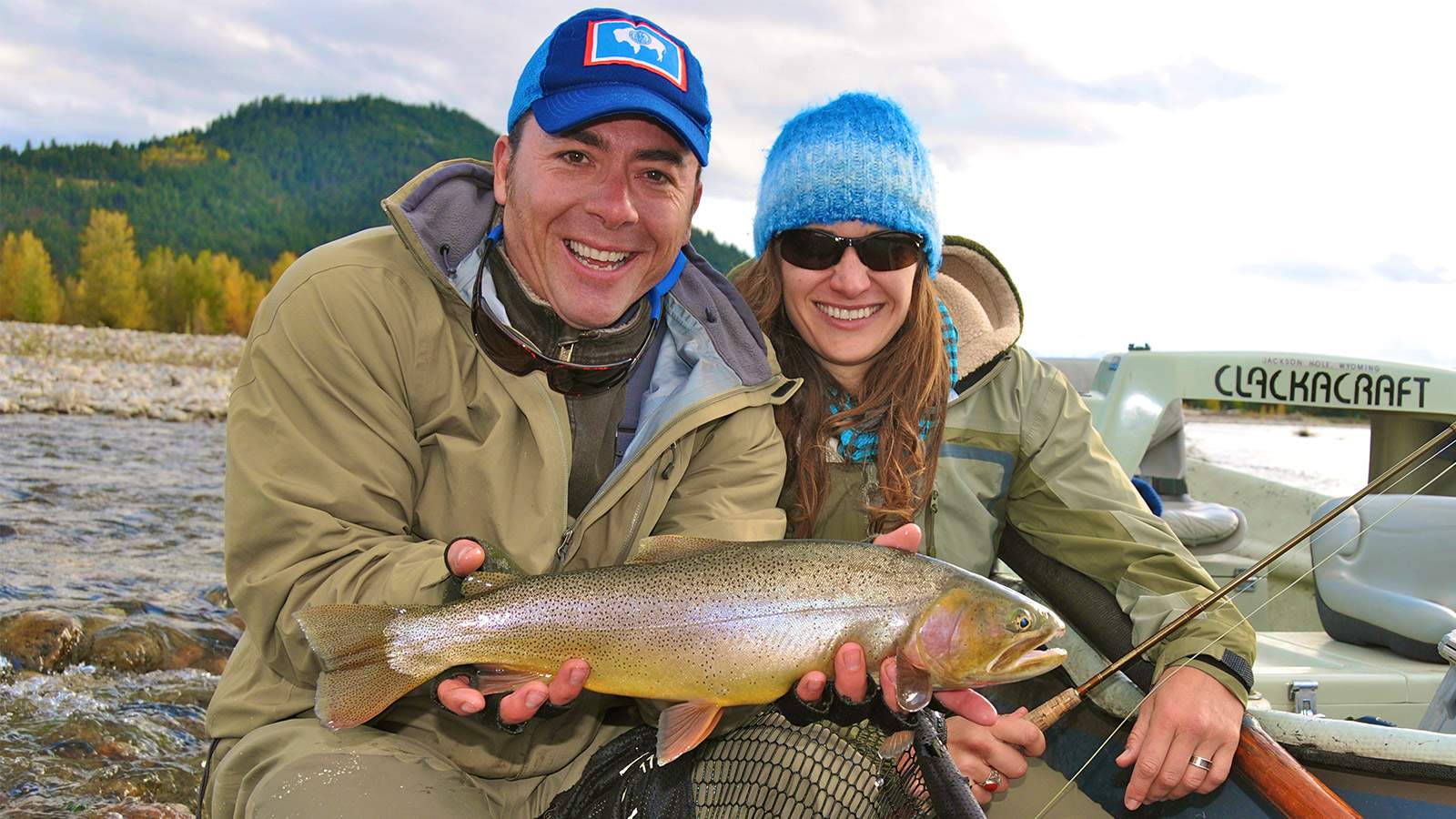 Best Trout Fishing in Wyoming happy female angler with guide trout in hand