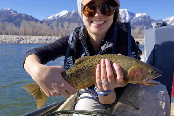 Snake River fly fishing female client with trout in hand